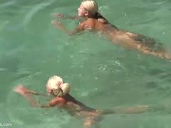 Süße Urlauberinnen beim FKK-Schwimmen im Meer